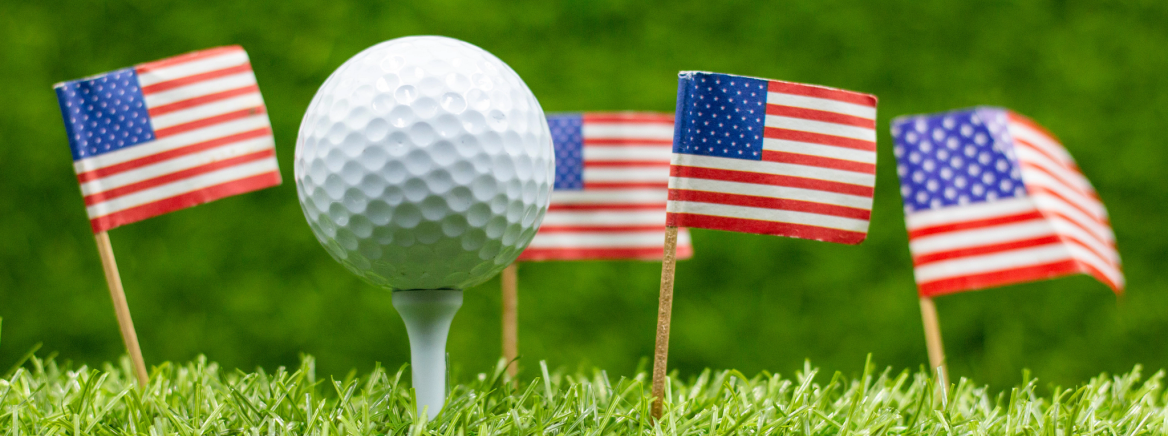Golf Ball with American Flags Close up shot of a golf ball on a tee with four American flags in the background.