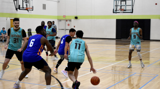 Two teams playing basketball in a gym.