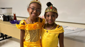 Two girls dressed as princesses for a program.
