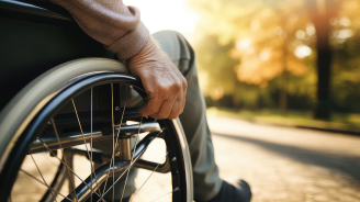 closeup of disabled person riding in wheelchair at park. disability insurance. generative AI
