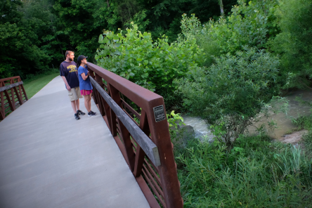 Two people looking over a bridge on the greenway.