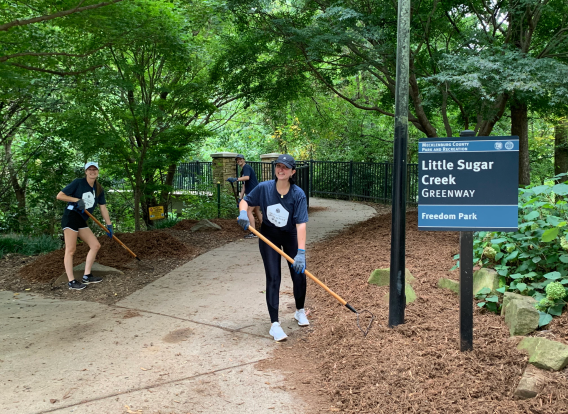 Volunteers spreading mulch on greenway.