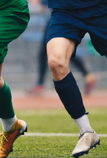 photo of soccer players' feet with one attacker dribbling while being surrounded by defenders.