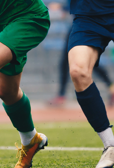 photo of soccer players' feet with one attacker dribbling while being surrounded by defenders.