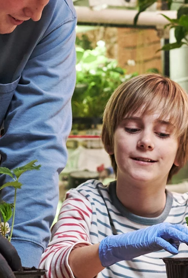 Young man teaching youth planting